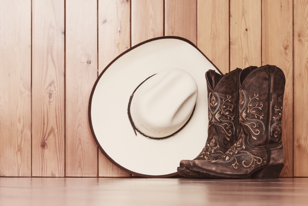 Cowgirl,Embroidered,Boots,And,White,Hat,On,Wooden,Background,-